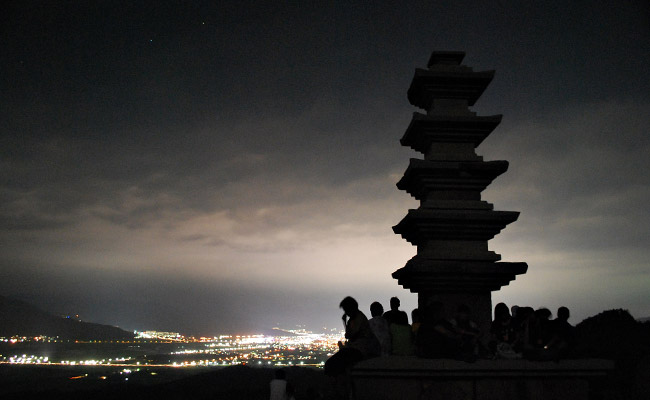 늠비봉 오층석탑 아래에 앉아 야경을 보는 사람들