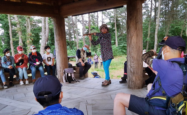 금오정에서 피리를 연주하는 사람과 주위로 앉은 사람들