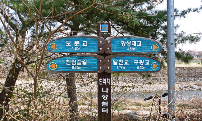 현위치 나정쉼터에서 에서 보문교, 황성대교, 알천교·구황교 천림숲길 가는 길을 안내한 표지판