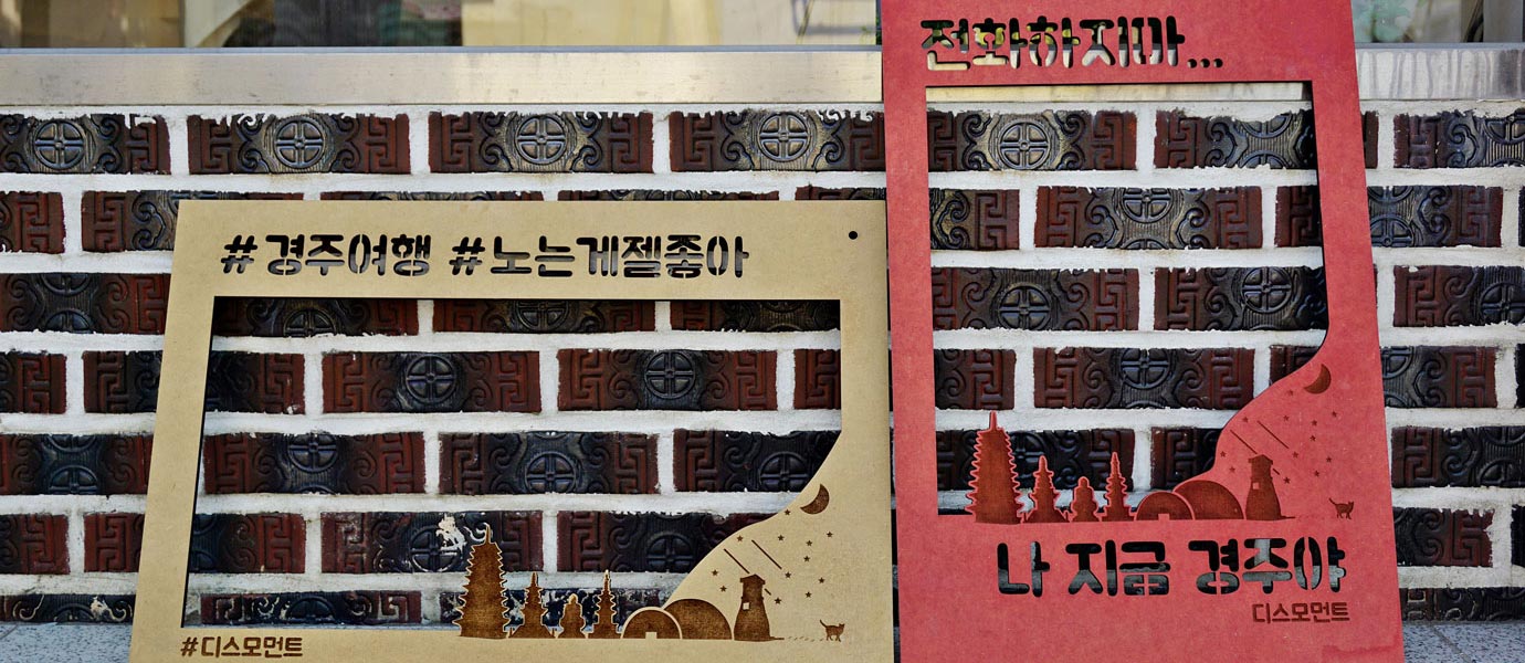 디스모먼트 앞에 있는 입간판 - 간판내용 : #경주여행 #노는게젤좋아 #디스모먼트 , 전화하지마.. 나 지금 경주야 디스모먼트