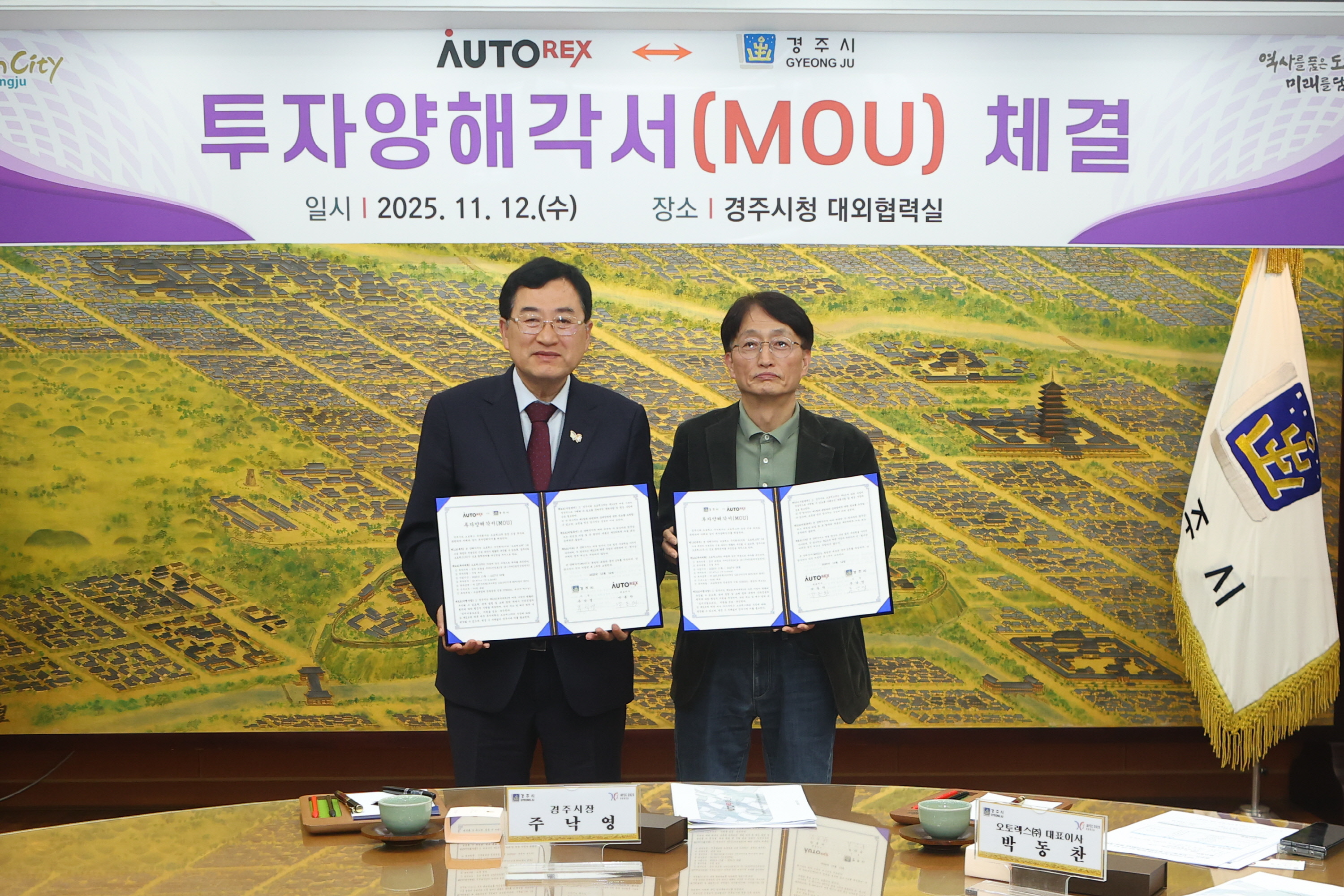 경주시청 대외협력실에서 열린 투자양해각서(MOU) 체결식에서 주낙영 경주시장과 박동찬 오토렉스(주) 대표이사가 협약서를 교환하며 기념촬영을 하고 있다
